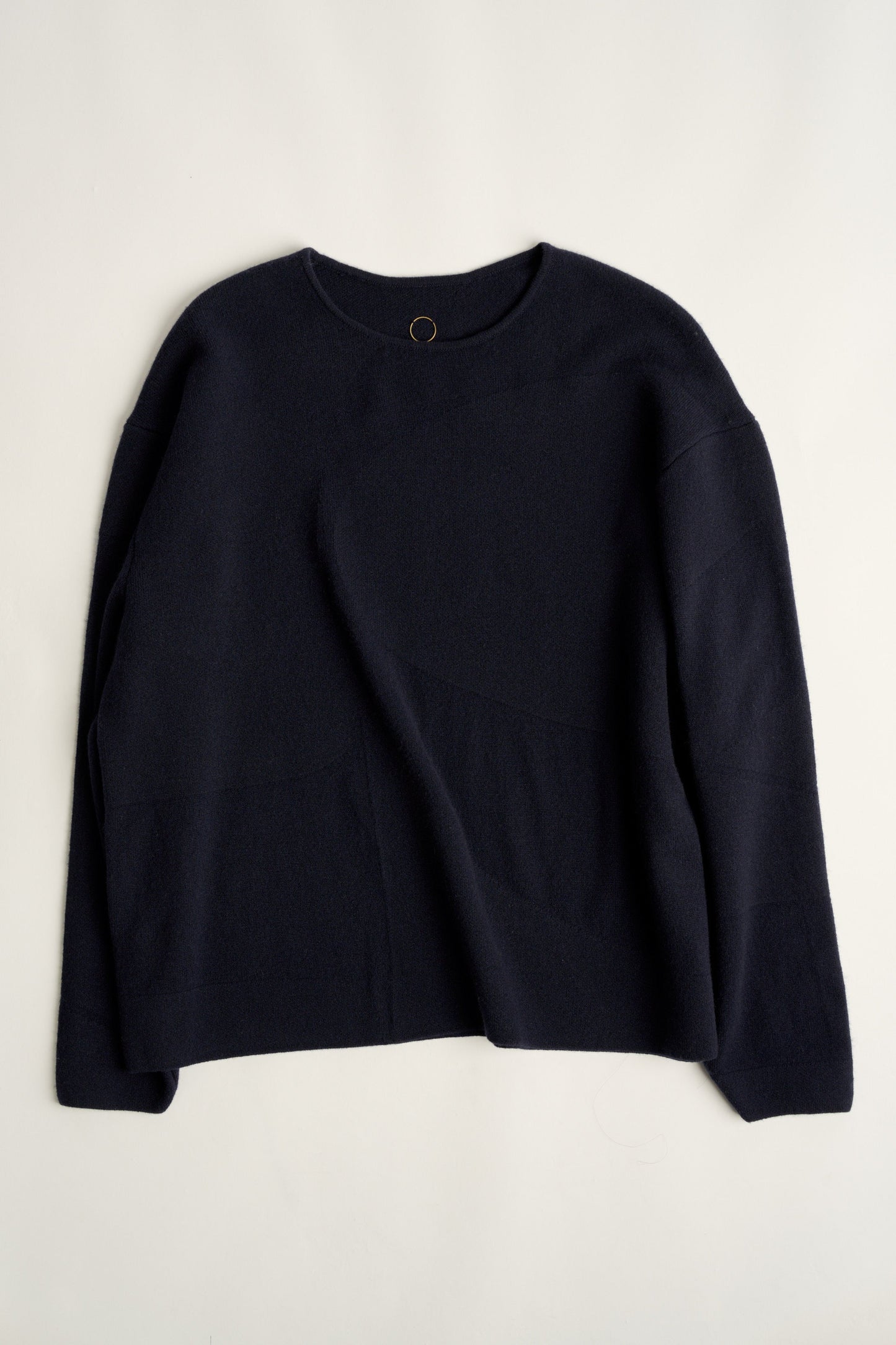 This image features the Arouc Sweater, a stylish and cozy garment ideal for everyday wear. The sweater displays a boxy silhouette and is crafted from a knitted jacquard fabric, presenting a subtle yet sophisticated pattern.