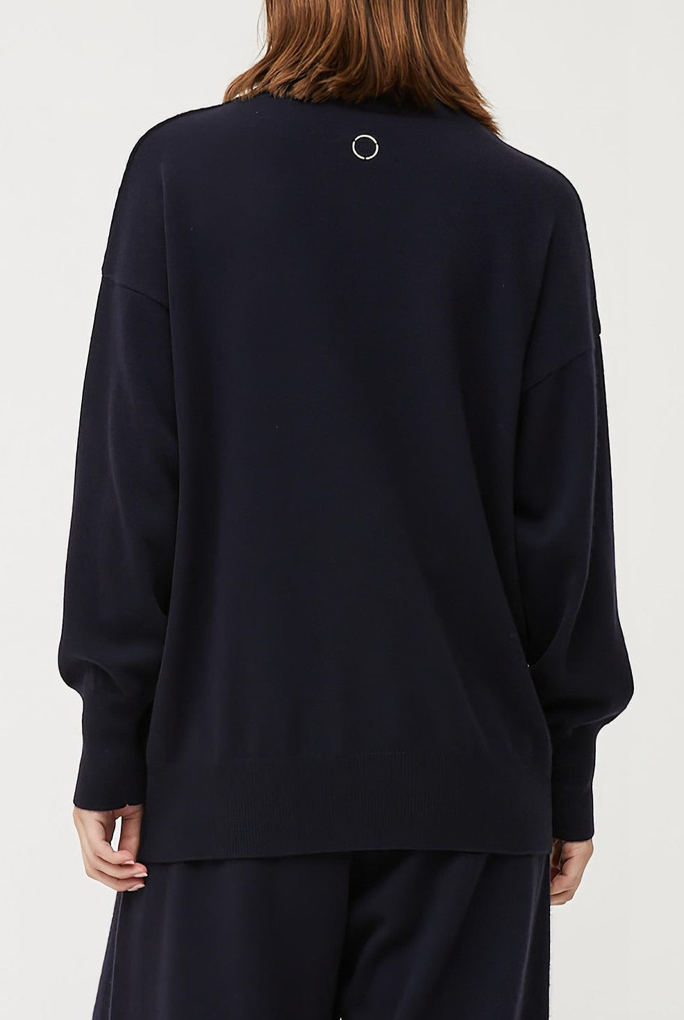 This image features the Kotto Sweater, highlighting its high-neck design and snug, comfortable fit. The sweater is presented in a classic, versatile ocean color, which enhances its elegant and timeless appeal.