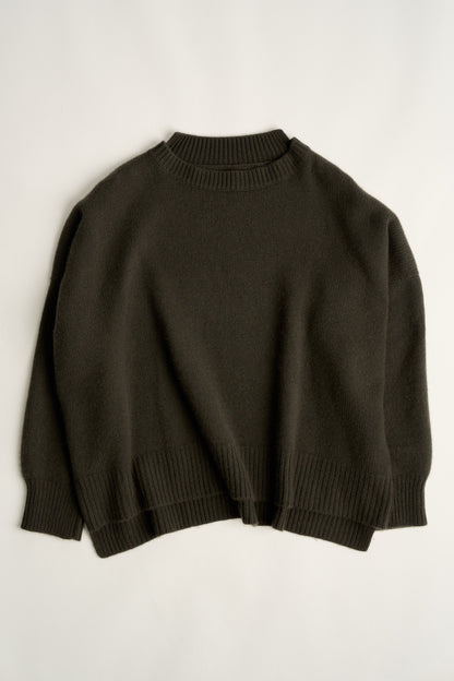 This image features the Aila Sweater, a stylish and versatile garment displayed on a model. The sweater is crafted in a chunky jersey stitch, offering a cozy and comfortable fit.