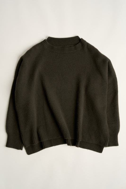 This image features the Aila Sweater, a stylish and versatile garment displayed on a model. The sweater is crafted in a chunky jersey stitch, offering a cozy and comfortable fit.