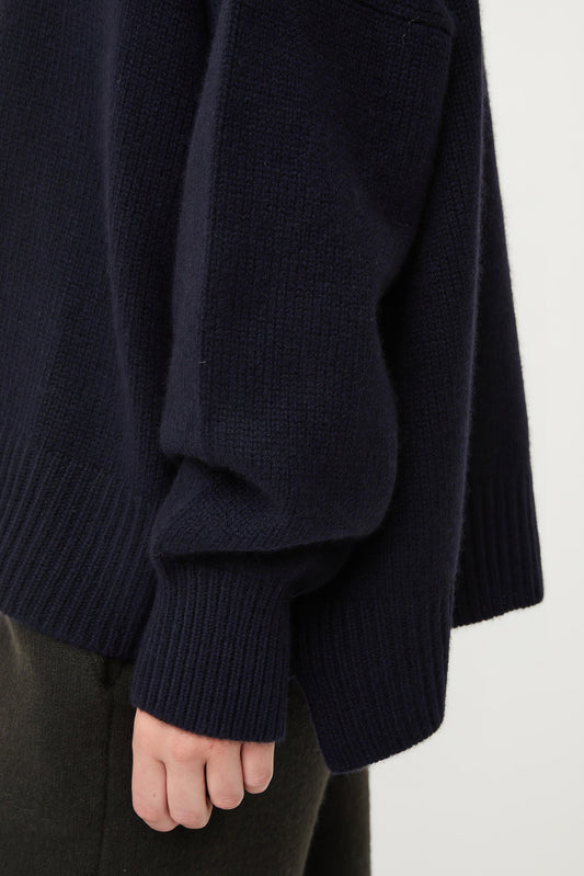 This image features the Aila Sweater, a stylish and versatile garment displayed on a model. The sweater is crafted in a chunky jersey stitch, offering a cozy and comfortable fit.