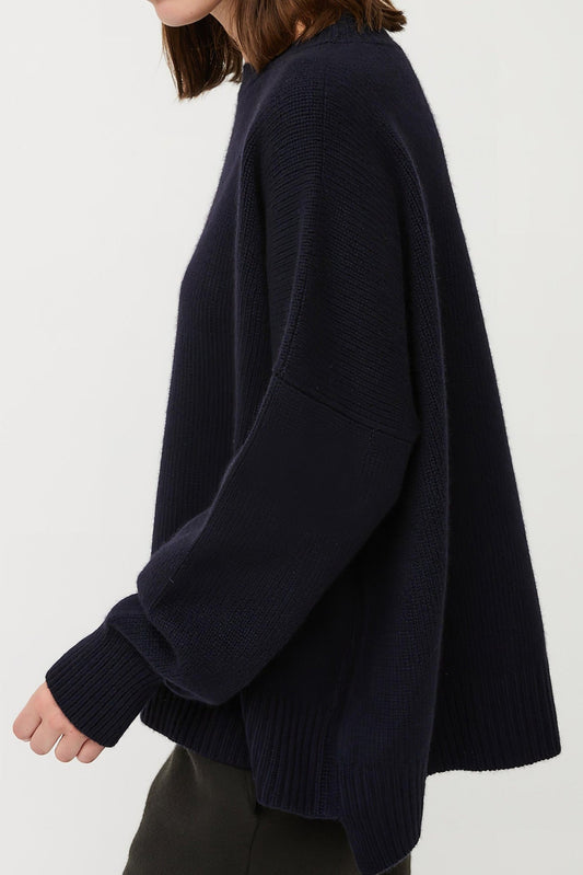 This image features the Aila Sweater, a stylish and versatile garment displayed on a model. The sweater is crafted in a chunky jersey stitch, offering a cozy and comfortable fit.