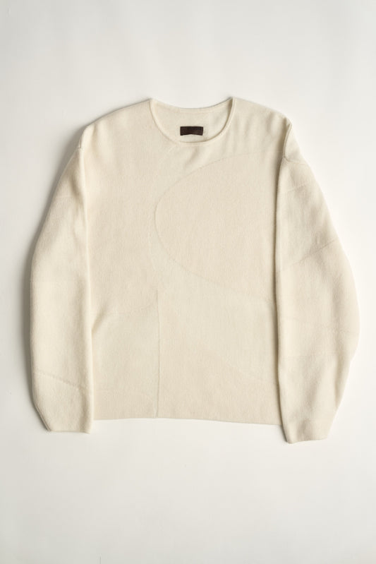 This image features the Arouc Sweater, a stylish and cozy garment ideal for everyday wear. The sweater displays a boxy silhouette and is crafted from a knitted jacquard fabric, presenting a subtle yet sophisticated pattern.