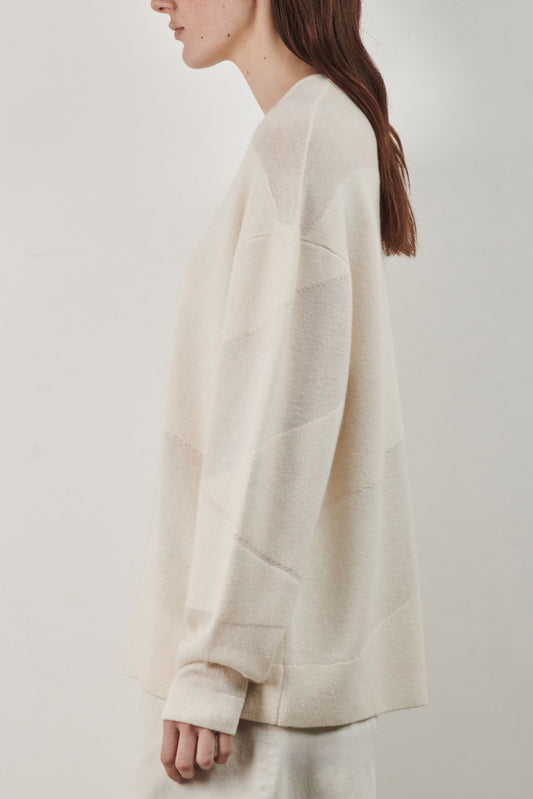 This image features the Arouc Sweater, a stylish and cozy garment ideal for everyday wear. The sweater displays a boxy silhouette and is crafted from a knitted jacquard fabric, presenting a subtle yet sophisticated pattern.