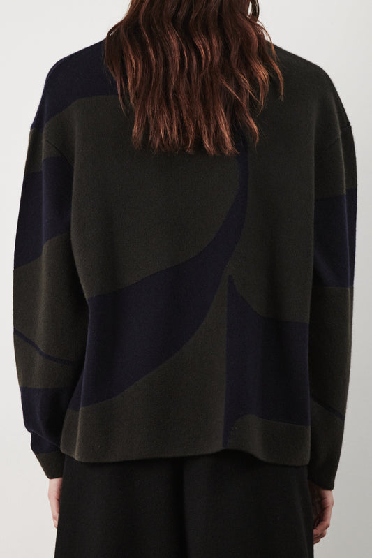 This image features the Arouc Sweater, a stylish and cozy garment ideal for everyday wear. The sweater displays a boxy silhouette and is crafted from a knitted jacquard fabric, presenting a subtle yet sophisticated pattern.