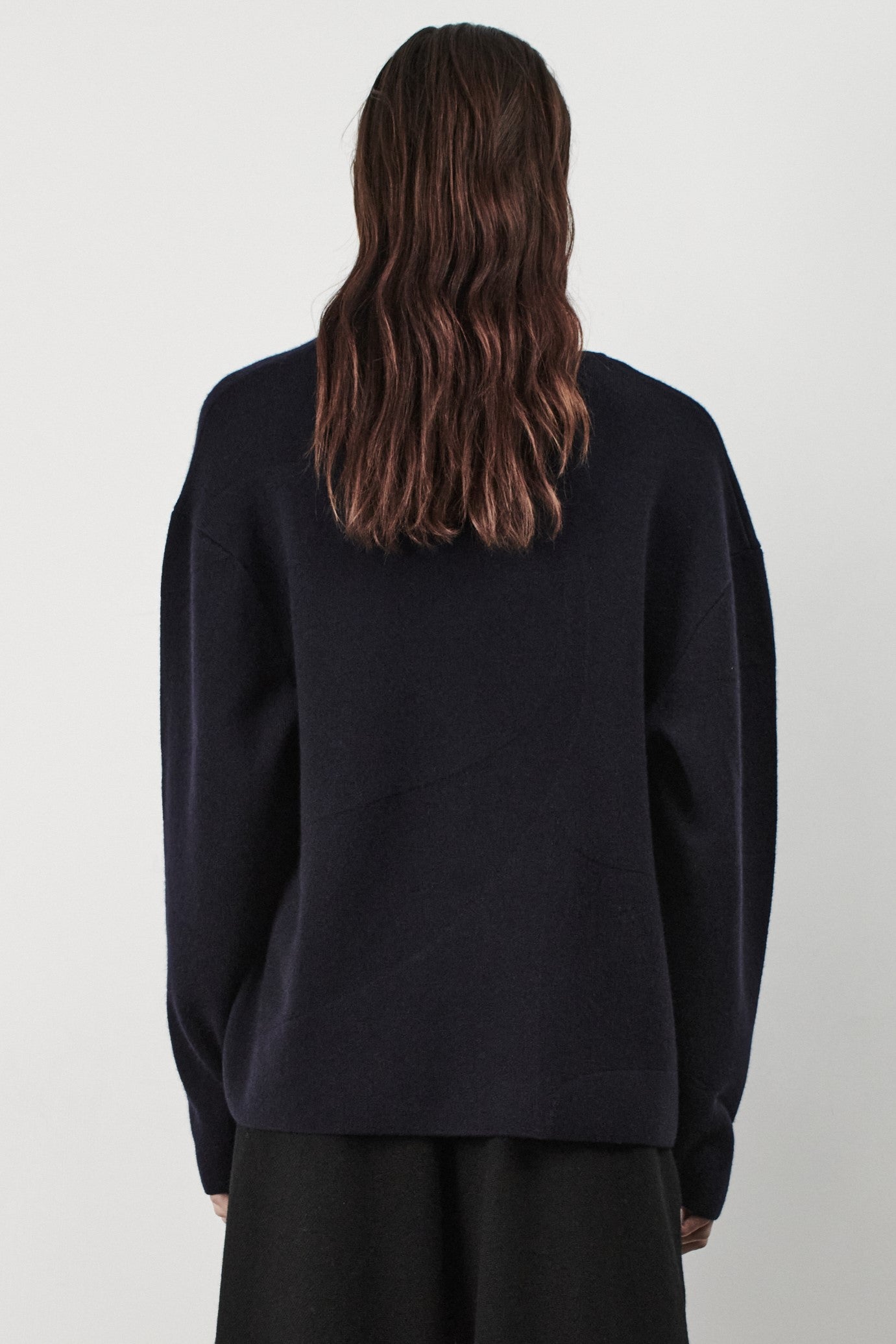 This image features the Arouc Sweater, a stylish and cozy garment ideal for everyday wear. The sweater displays a boxy silhouette and is crafted from a knitted jacquard fabric, presenting a subtle yet sophisticated pattern.