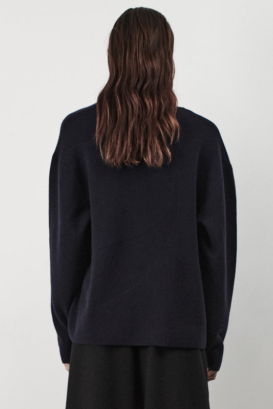This image features the Arouc Sweater, a stylish and cozy garment ideal for everyday wear. The sweater displays a boxy silhouette and is crafted from a knitted jacquard fabric, presenting a subtle yet sophisticated pattern.