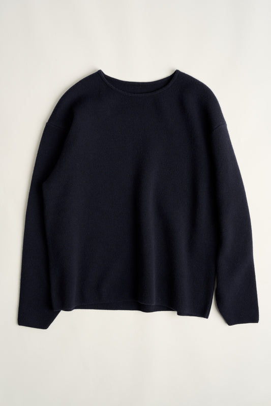This image features the Axa Sweater, a stylish and comfortable piece that showcases an oversized fit with drop shoulders and sculpted, rounded sleeves. The sweater is knitted using a structured jacquard stitch, which adds texture and depth to its appearance.