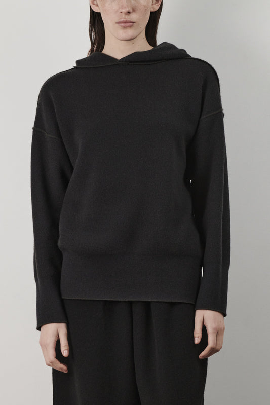 This image features a luxurious forest cashmere hoodie, modeled by a female. The hoodie boasts a modern and minimalist design, with a relaxed fit that enhances its appeal.