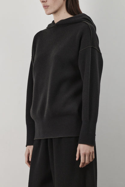 This image features a luxurious forest cashmere hoodie, modeled by a female. The hoodie boasts a modern and minimalist design, with a relaxed fit that enhances its appeal.