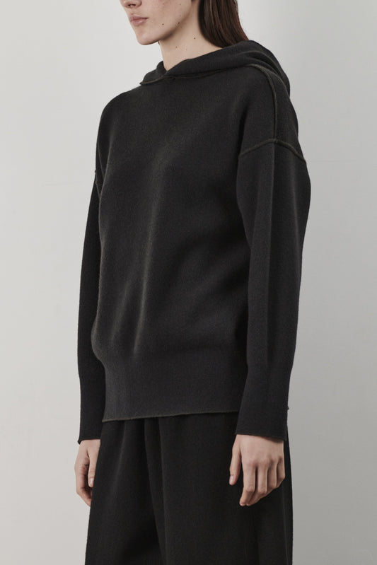 This image features a luxurious forest cashmere hoodie, modeled by a female. The hoodie boasts a modern and minimalist design, with a relaxed fit that enhances its appeal.