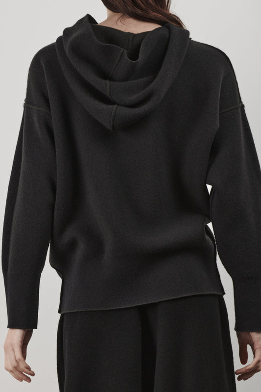 This image features a luxurious forest cashmere hoodie, modeled by a female. The hoodie boasts a modern and minimalist design, with a relaxed fit that enhances its appeal.