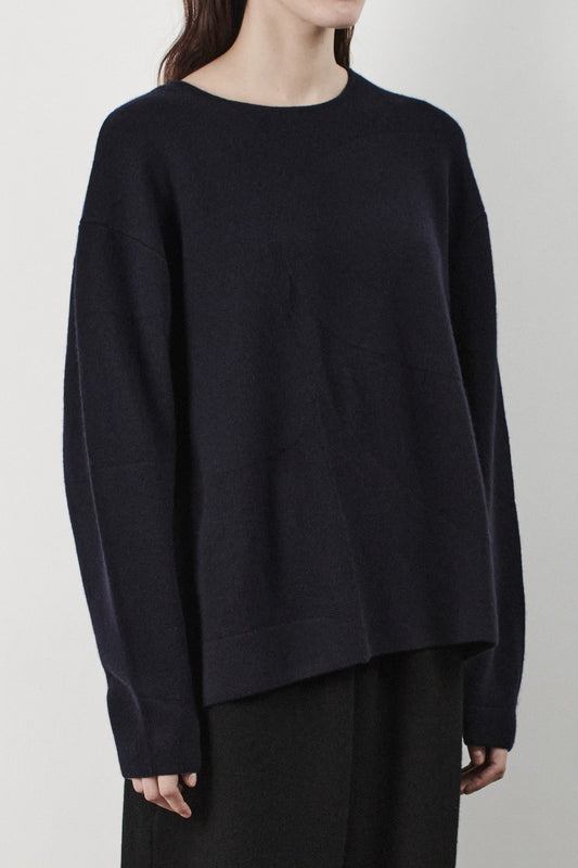 This image features the Arouc Sweater, a stylish and cozy garment ideal for everyday wear. The sweater displays a boxy silhouette and is crafted from a knitted jacquard fabric, presenting a subtle yet sophisticated pattern.