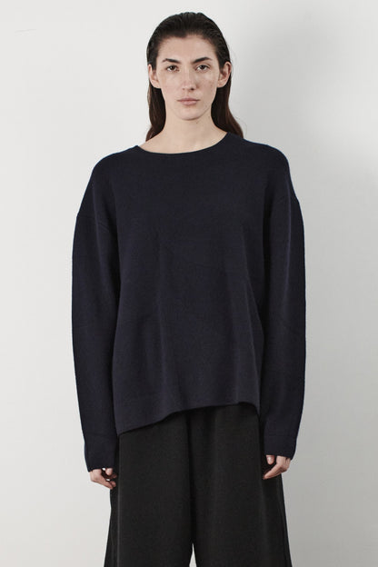 This image features the Arouc Sweater, a stylish and cozy garment ideal for everyday wear. The sweater displays a boxy silhouette and is crafted from a knitted jacquard fabric, presenting a subtle yet sophisticated pattern.