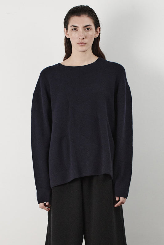 This image features the Arouc Sweater, a stylish and cozy garment ideal for everyday wear. The sweater displays a boxy silhouette and is crafted from a knitted jacquard fabric, presenting a subtle yet sophisticated pattern.