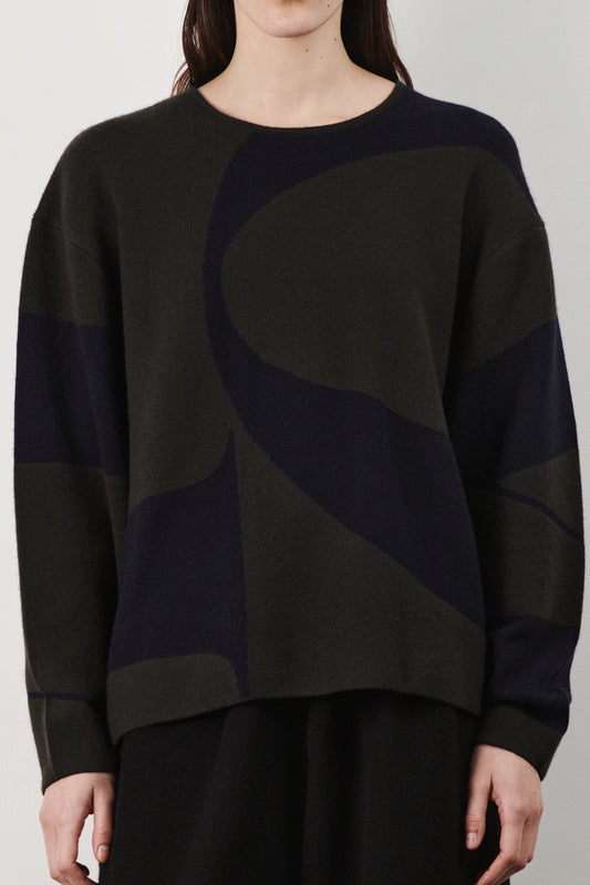 This image features the Arouc Sweater, a stylish and cozy garment ideal for everyday wear. The sweater displays a boxy silhouette and is crafted from a knitted jacquard fabric, presenting a subtle yet sophisticated pattern.
