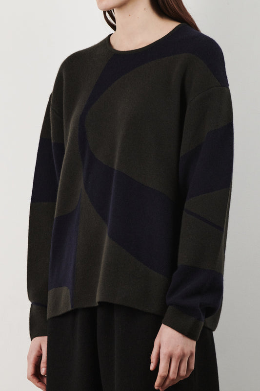 This image features the Arouc Sweater, a stylish and cozy garment ideal for everyday wear. The sweater displays a boxy silhouette and is crafted from a knitted jacquard fabric, presenting a subtle yet sophisticated pattern.