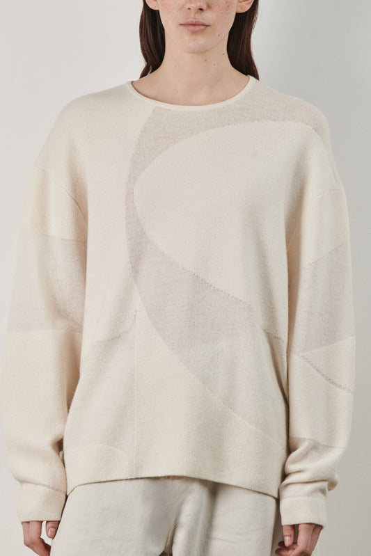 This image features the Arouc Sweater, a stylish and cozy garment ideal for everyday wear. The sweater displays a boxy silhouette and is crafted from a knitted jacquard fabric, presenting a subtle yet sophisticated pattern.