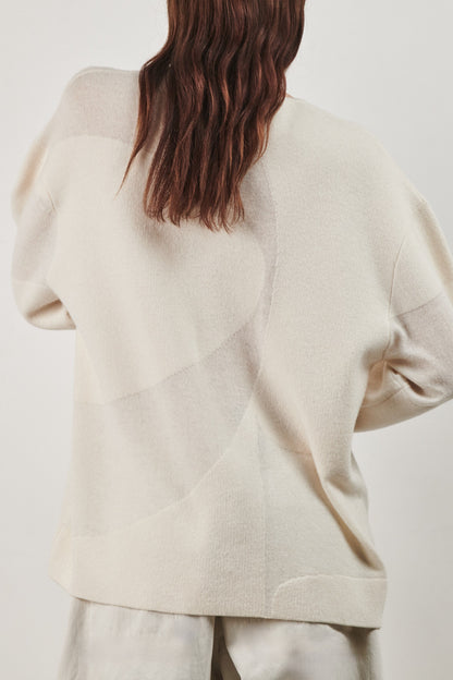 This image features the Arouc Sweater, a stylish and cozy garment ideal for everyday wear. The sweater displays a boxy silhouette and is crafted from a knitted jacquard fabric, presenting a subtle yet sophisticated pattern.