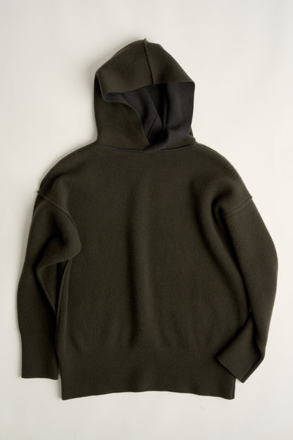 This image features a luxurious forest cashmere hoodie, modeled by a female. The hoodie boasts a modern and minimalist design, with a relaxed fit that enhances its appeal.