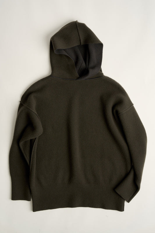 This image features a luxurious forest cashmere hoodie, modeled by a female. The hoodie boasts a modern and minimalist design, with a relaxed fit that enhances its appeal.