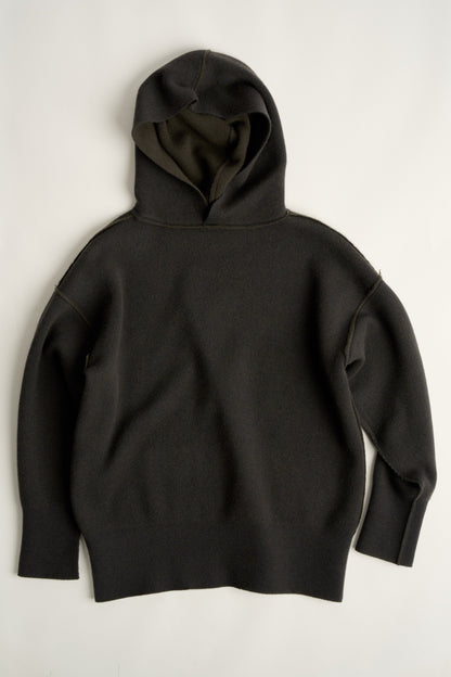 This image features a luxurious forest cashmere hoodie, modeled by a female. The hoodie boasts a modern and minimalist design, with a relaxed fit that enhances its appeal.