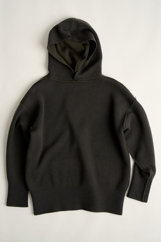 This image features a luxurious forest cashmere hoodie, modeled by a female. The hoodie boasts a modern and minimalist design, with a relaxed fit that enhances its appeal.