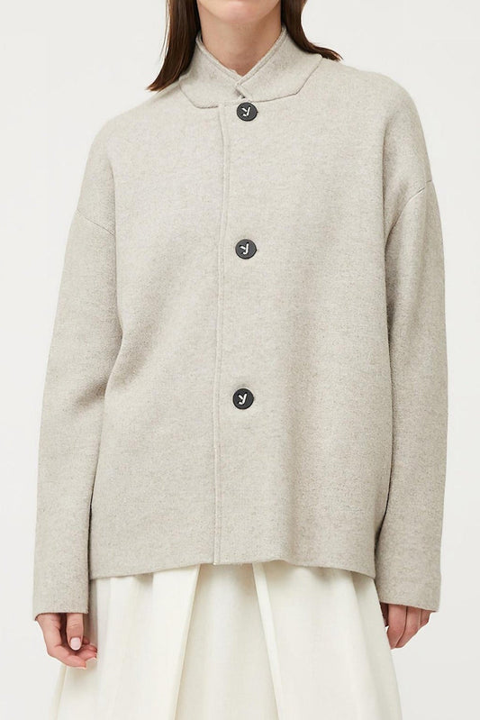 This image features a stylish and practical wind jacket from Oyuna's core collection. The jacket is presented in a relaxed-fit style with a stand-up collar, highlighted by oyuna's signature buttons and welt pockets that enhance its functional appeal.